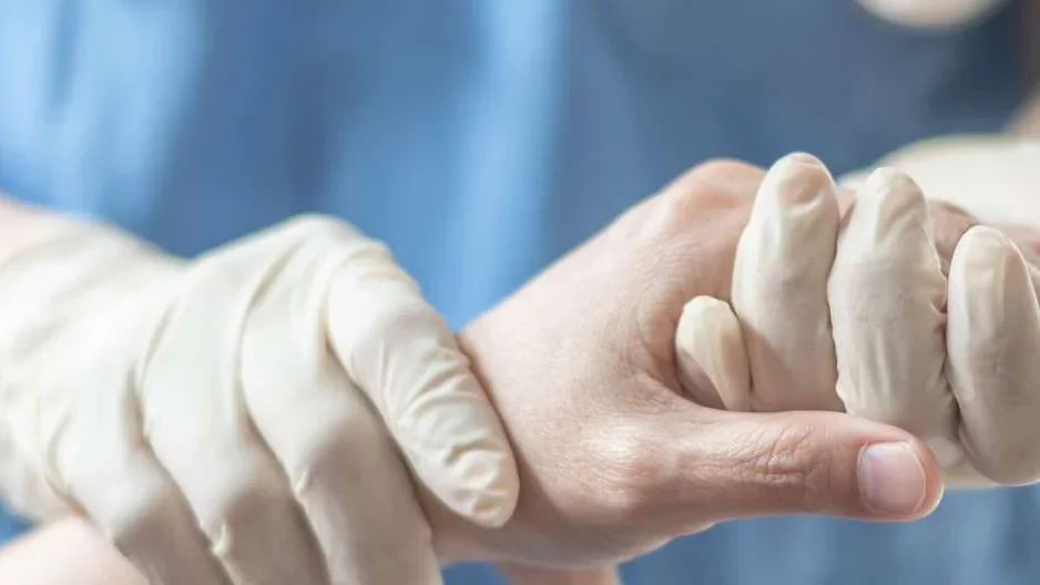 gloved hand holding hand