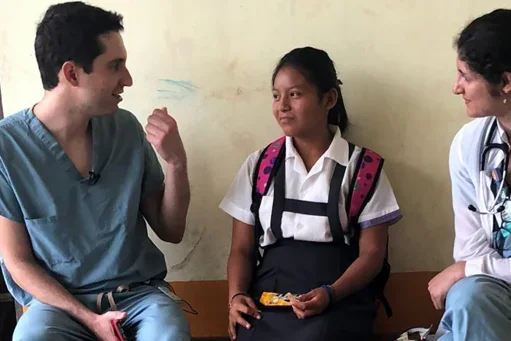 DGSOM medical students sitting on a bench with a pediatric patient