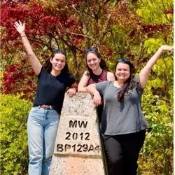Three MS4 students standing on a rock in Malawi